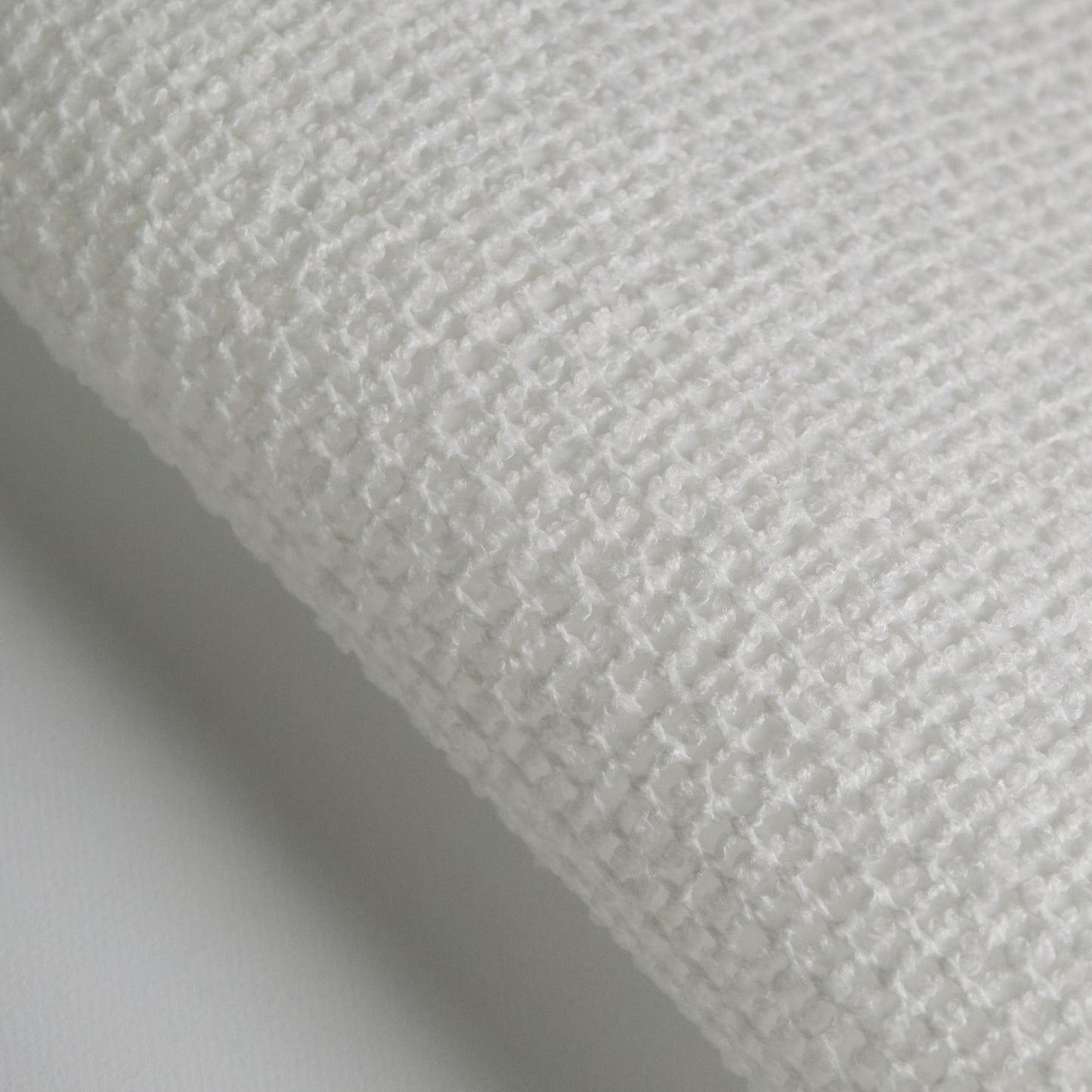 Close-up of BOUCLE fabric showing textured white polyester weave for upholstery and design.