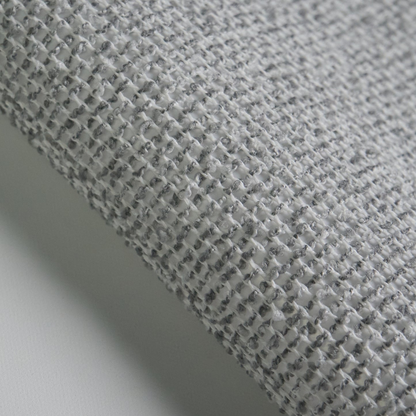 Close-up of BOUCLE fabric texture in grey, highlighting the woven pattern and soft feel.